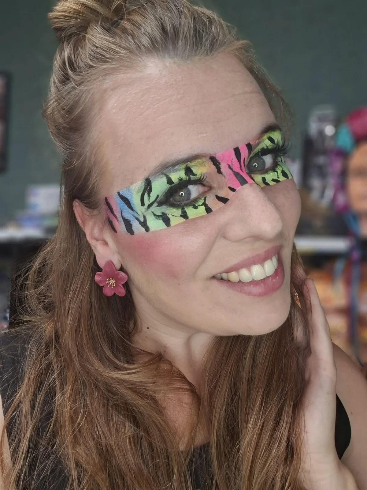 Linda van Schminkplezier met kleurrijke maskerschmink rond haar ogen